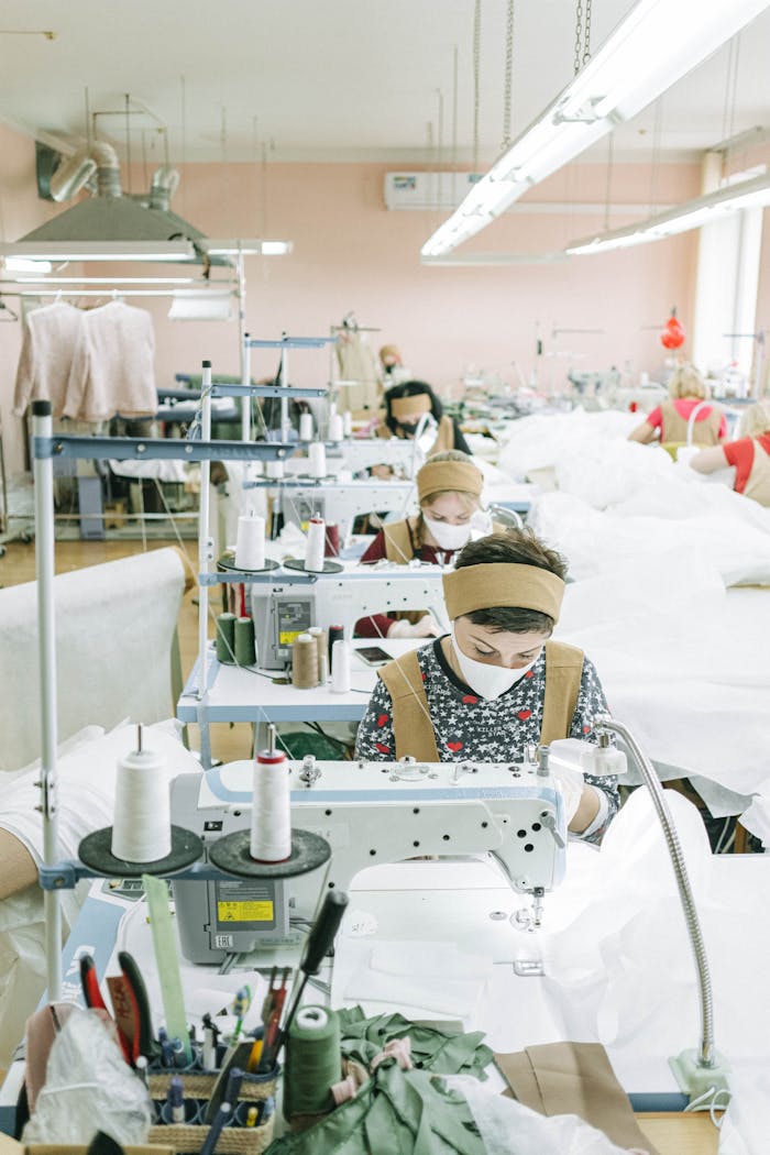 Women working with sewing machines in a textile factory, focused on production.